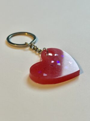 Bunt und glitzernd gestalteter Schlüsselanhänger aus Expoditharz in Form eines Herzen mit kleinen Herzen als Glitzer